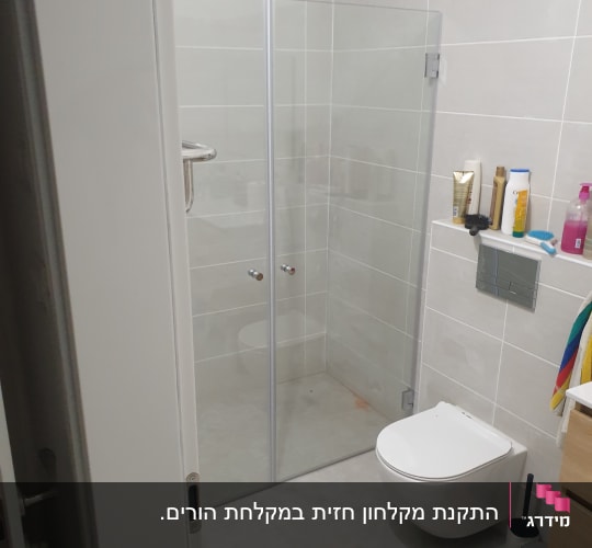 מקלחון זכוכית עם דלתות שקופות בחדר אמבטיה